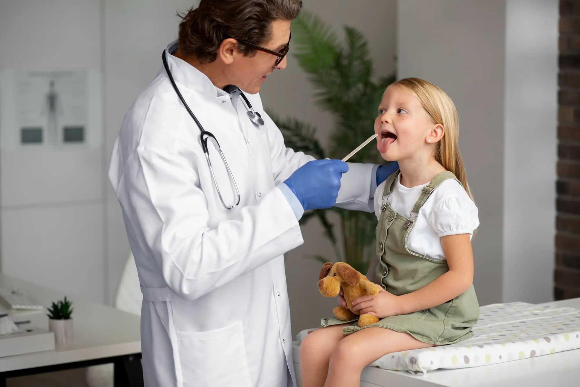 At Chauncey Orthodontics operates in Henderson, NV. A child sits smiling in a dental chair as the professional explains tongue thrust during their check-up.