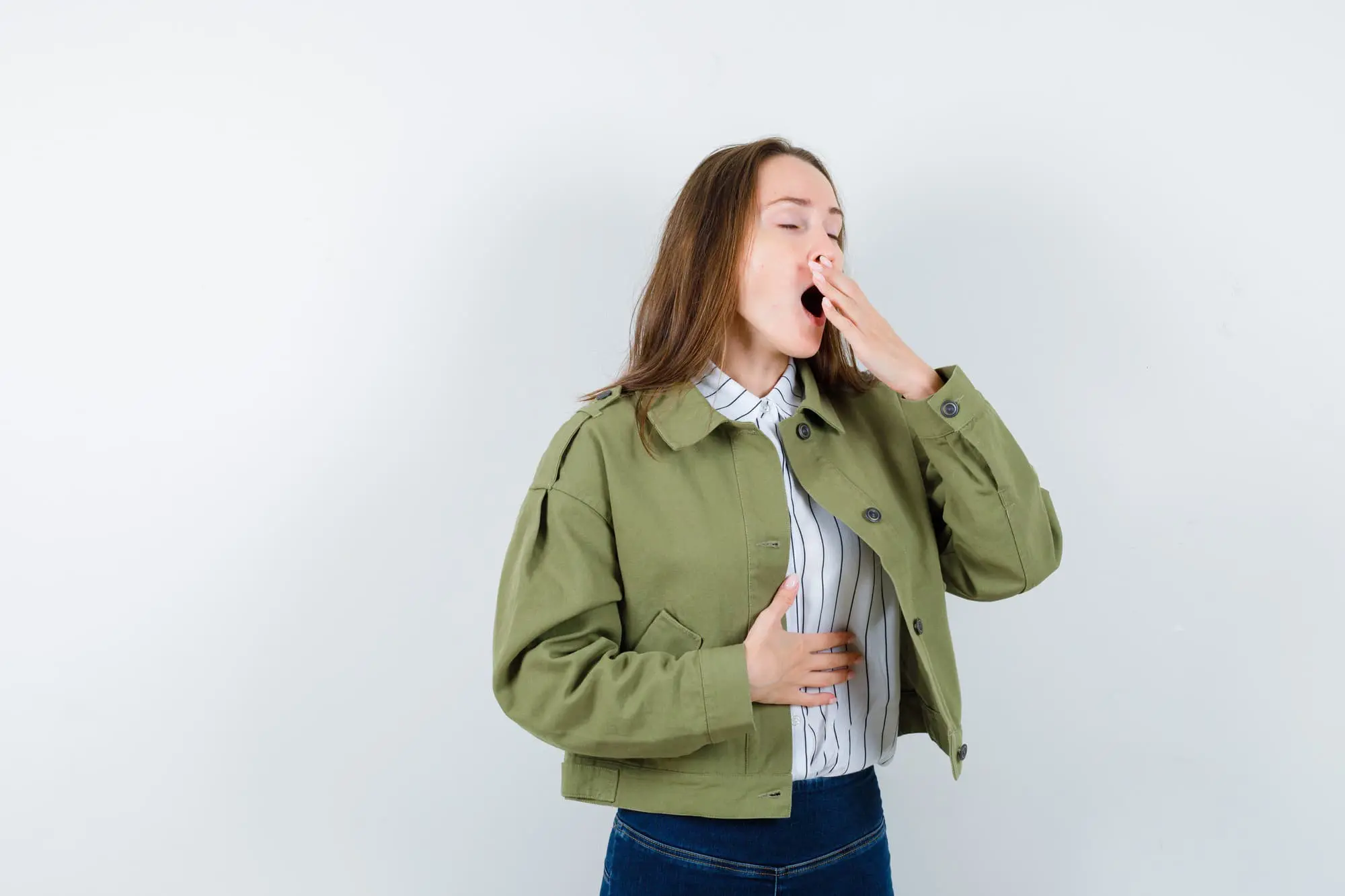 A woman wearing a green jacket discreetly covers his mouth, possibly to avoid revealing any mouth breathing when visiting Chauncey Orthodontics in Henderson, NV.