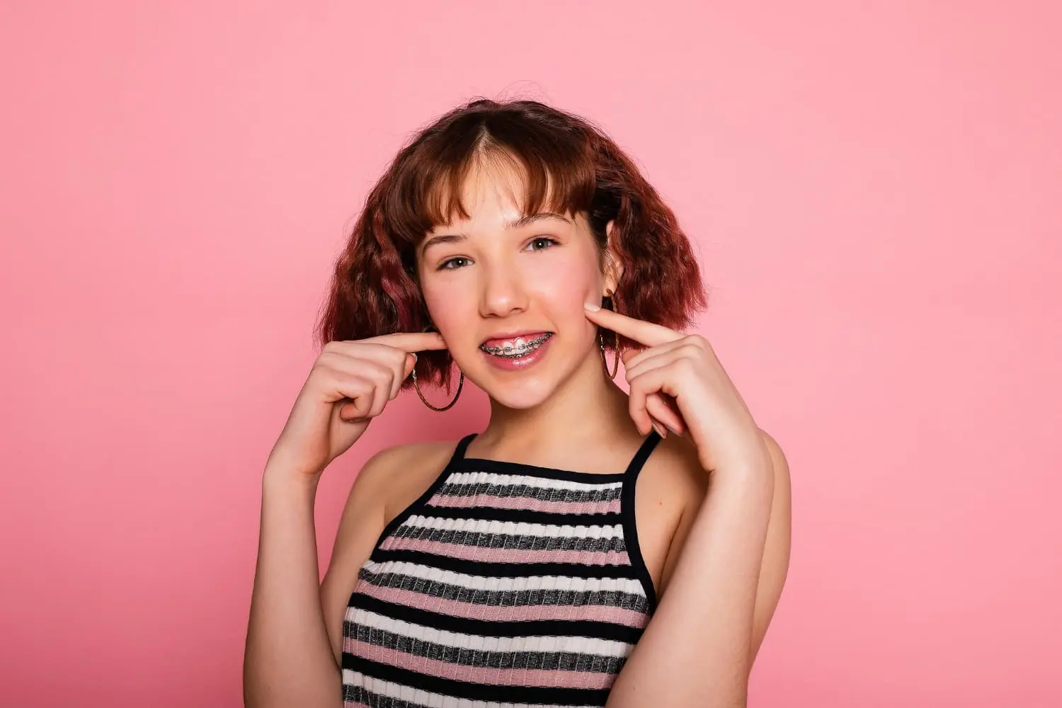 Smiling woman showcases her braces, revealing her decision in the Invisalign vs Braces debate at Chauncey Orthodontics operates in Henderson, NV.