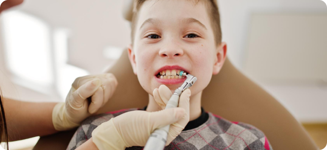 At Chauncey Orthodontics in Henderson NV, a pediatric orthodontist cleans a child's teeth as they sit comfortably in the dental chair.