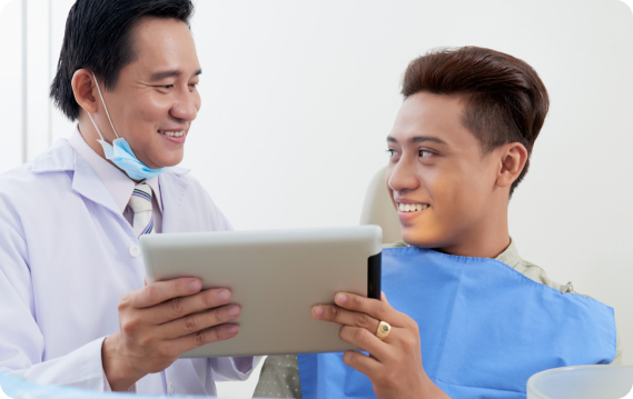 A dentist discusses jaw surgery options with a smiling patient, in a modern dental office in Henderson, NV.